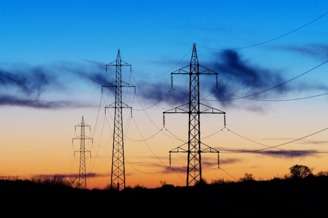 Silhouettes of power line towers.