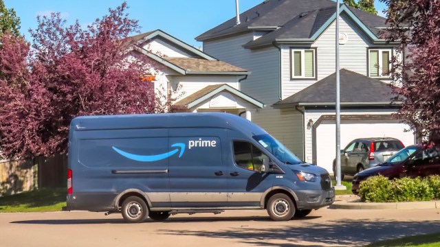 An Amazon Prime delivery van driving through a residential neighborhood.