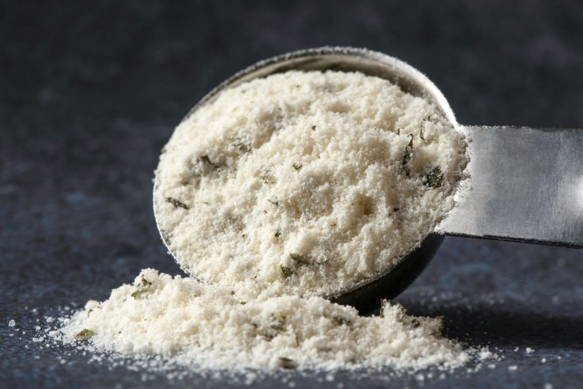 A metal measuring spoon filled with ranch powdered seasoning.
