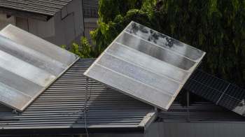 Two solar panels installed on a sloped roof.
