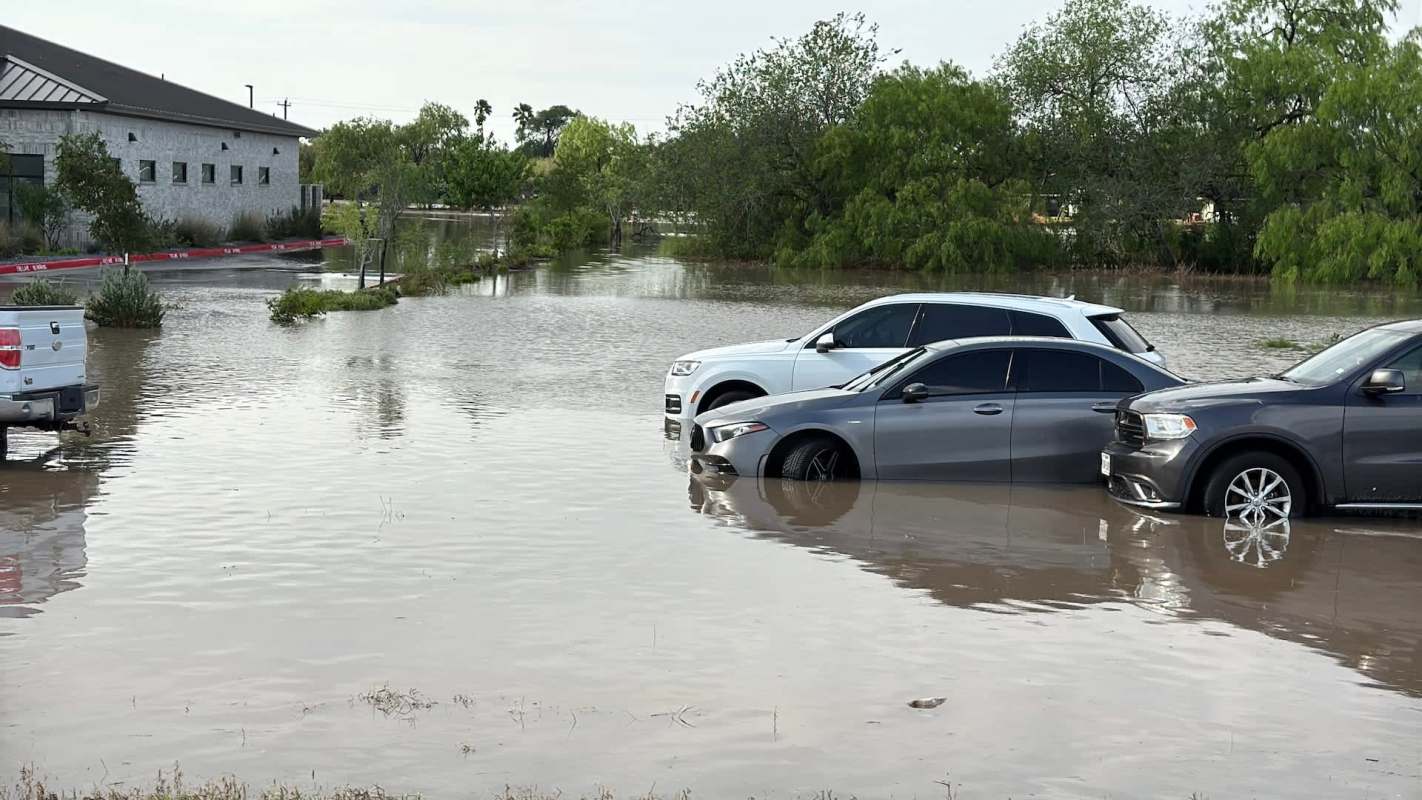 Several cars partially submerged in floodwaters.