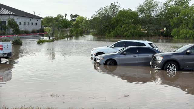 Several cars partially submerged in floodwaters.