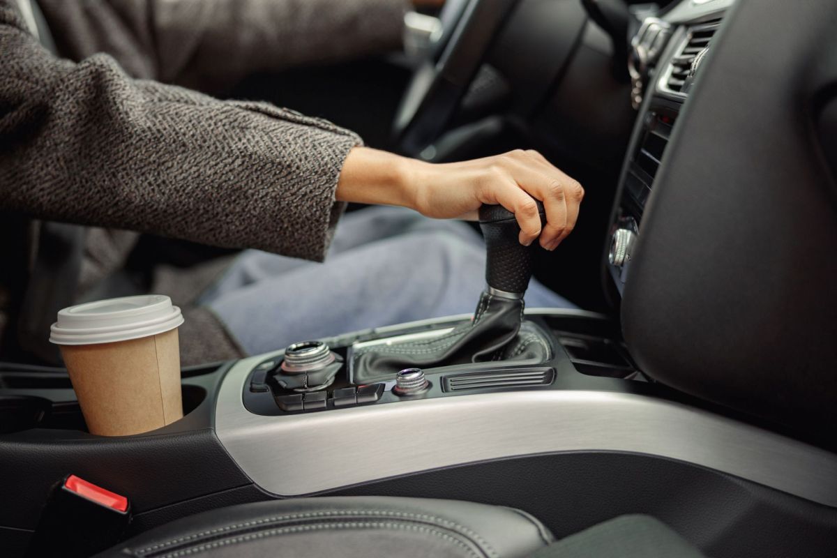A person shifts the gear in a car.