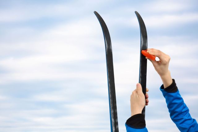A person putting wax on skis.