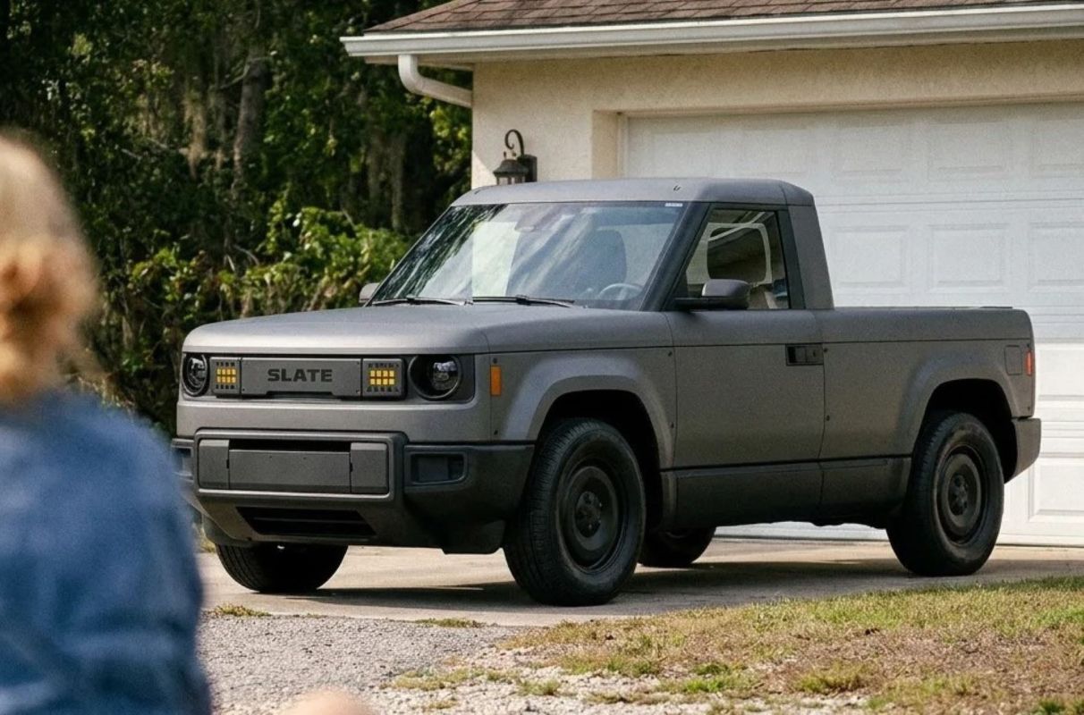 An electric pickup truck in front of a house.