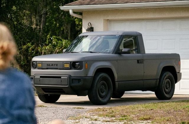 A Slate Auto electric truck in front of a house.
