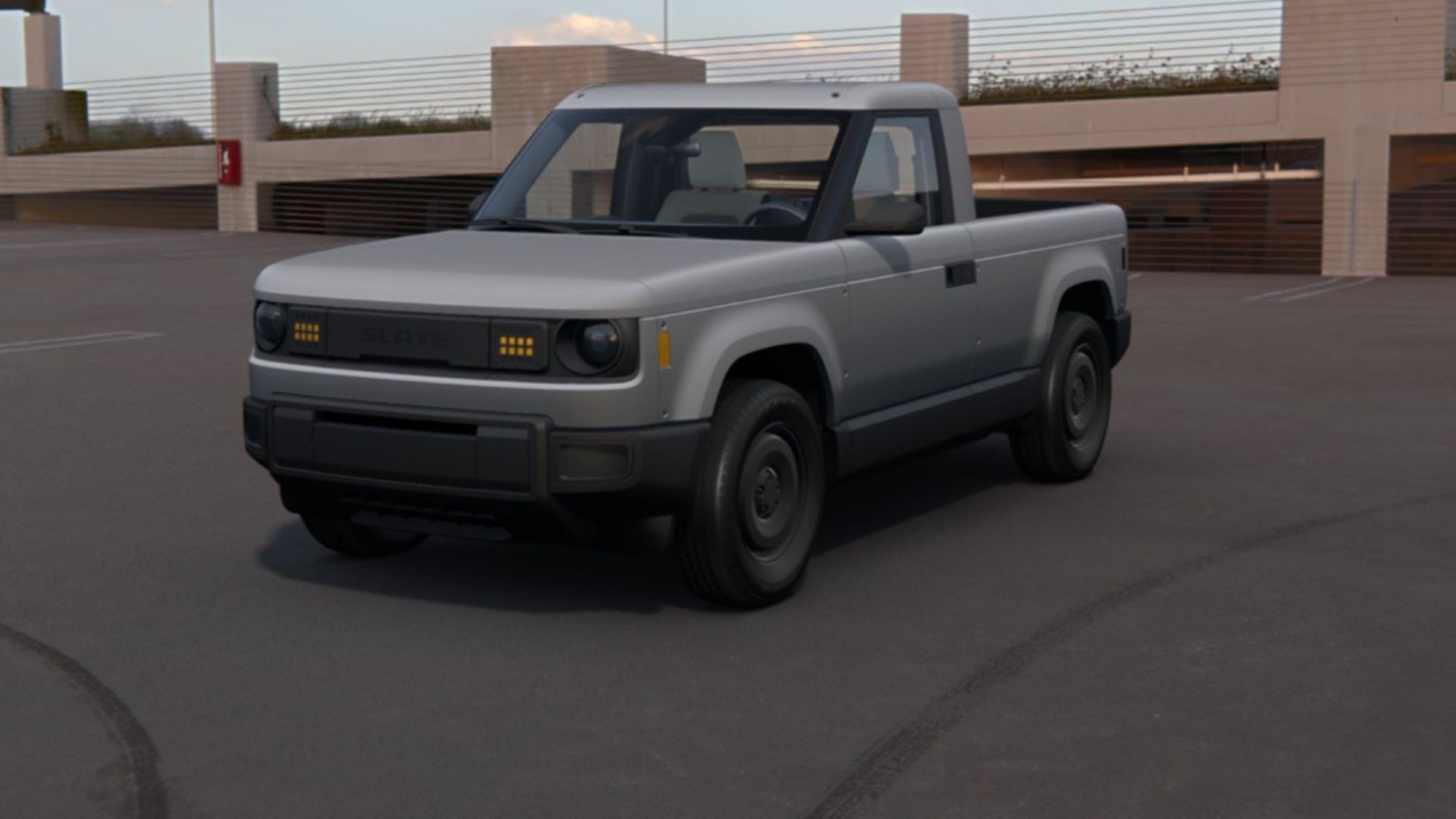 A gray pickup truck at the top of an empty parking garage.