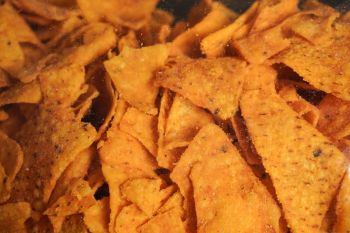 A close-up of crispy, orange tortilla chips with a textured surface.