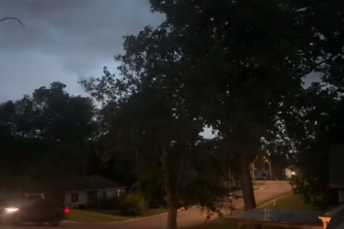 A dimly lit street at dusk during a thunderstorm.