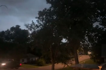 A dimly lit street at dusk during a thunderstorm.