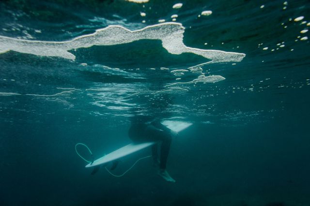 A surfer sitting on a surfboard in the ocean.