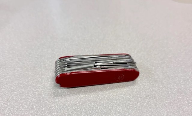 A red Swiss army knife with all its pieces closed.