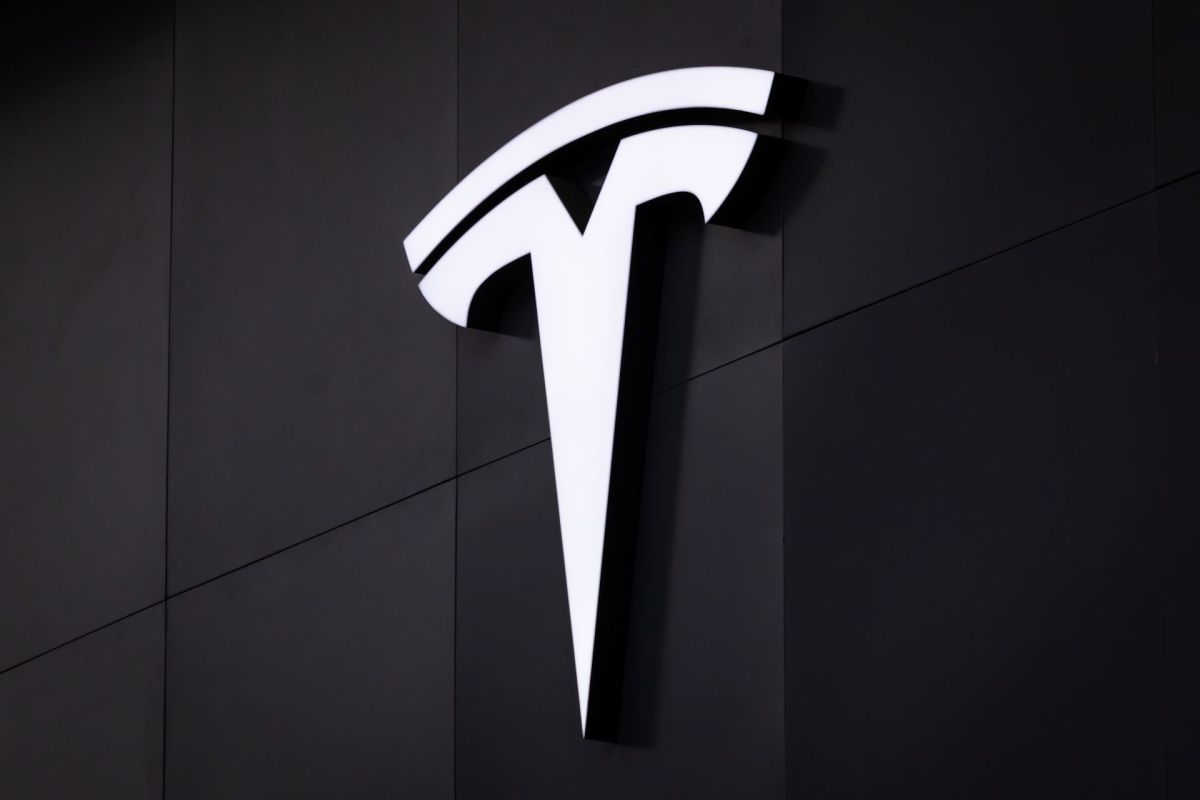 A white Tesla logo on a black background.