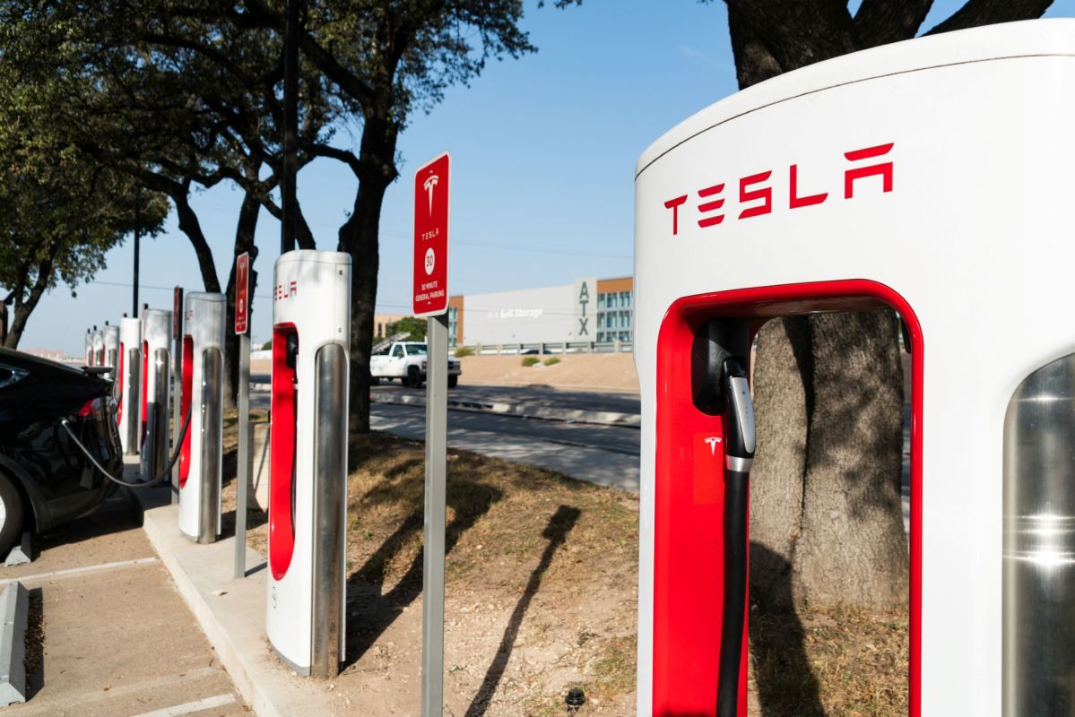 A row of Tesla charging stations in a parking lot.