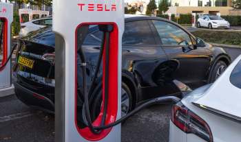 A black Tesla charging at a Supercharger station.