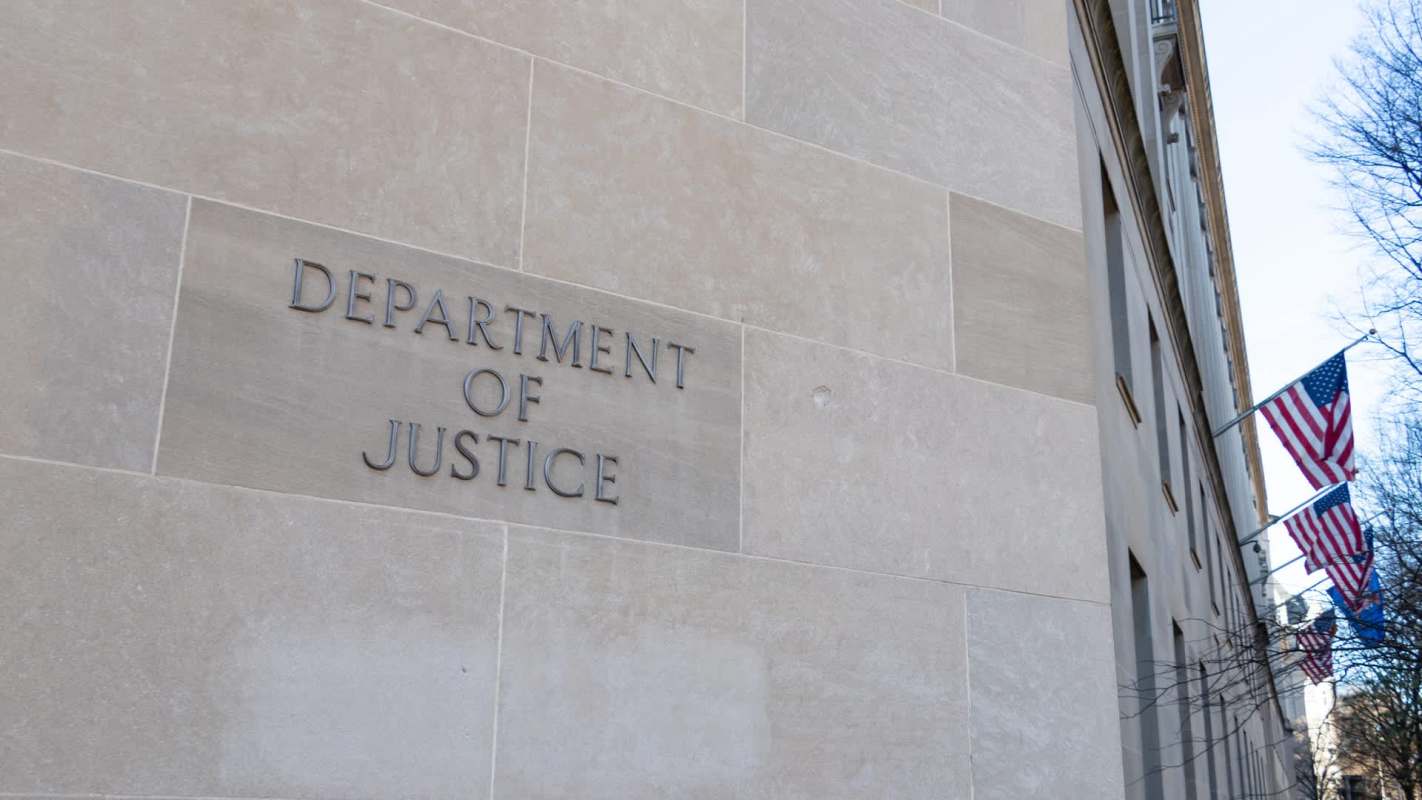 The engraved sign of the "Department of Justice" on a stone wall.