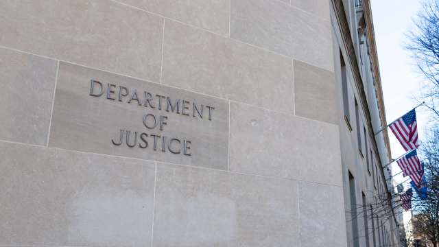The engraved sign of the "Department of Justice" on a stone wall.