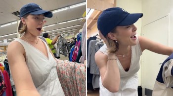 A woman in a white dress and baseball cap smiles excitedly while shopping in a thrift store.