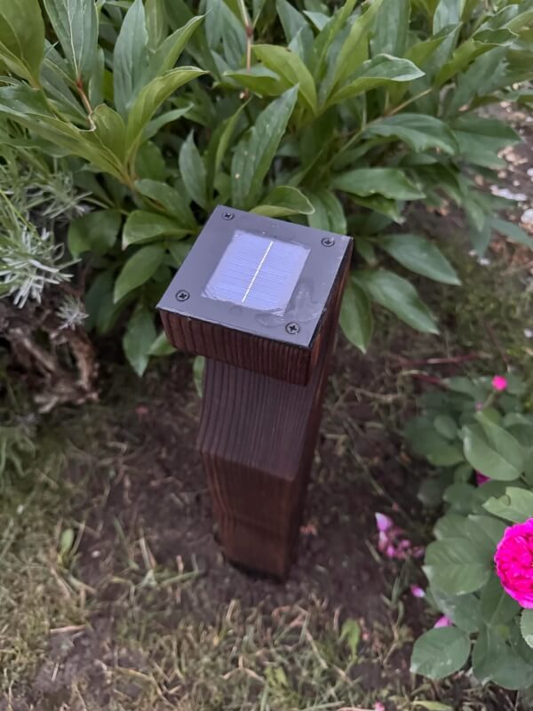 A close-up of the solar panel on top of the wooden lamp.