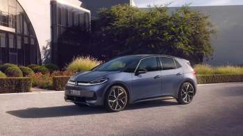 A Volkswagen electric car parked in front of a contemporary building.