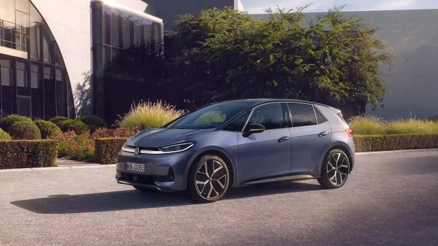 A Volkswagen electric car parked in front of a contemporary building.