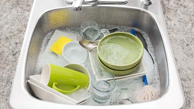 A sink filled with soapy water and dirty dishes.