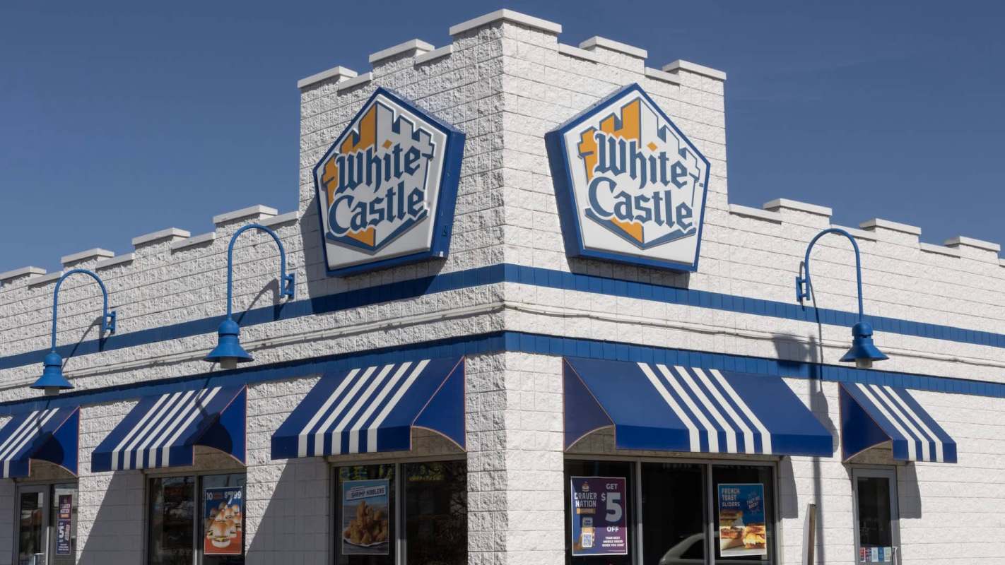 A White Castle fast-food restaurant featuring a blue and white striped awning and signage against a clear sky.