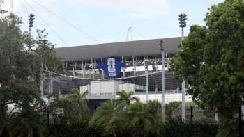A view of a partially obscured stadium with a FIFA World Cup 2026 banner against a backdrop of greenery.