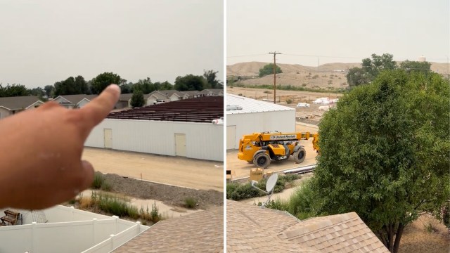 A person points toward a landscape covered in thick haze.