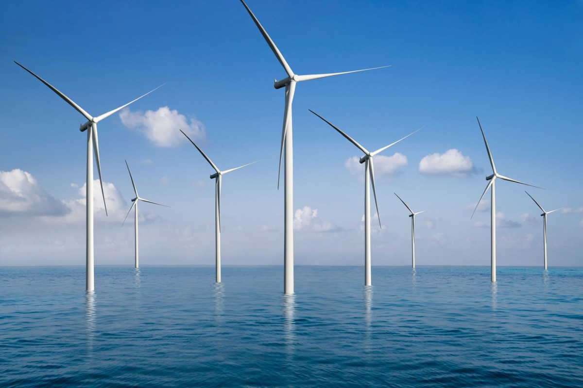 A row of wind turbines in the ocean.