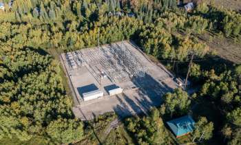 An aerial view of a power substation surrounded by trees.