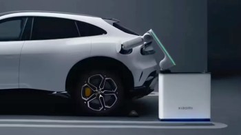 A white Xiaomi electric vehicle connected to a robotic battery-swapping station.
