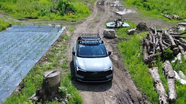 A Volvo EX30 Cross Country electric vehicle on a rural dirt road.