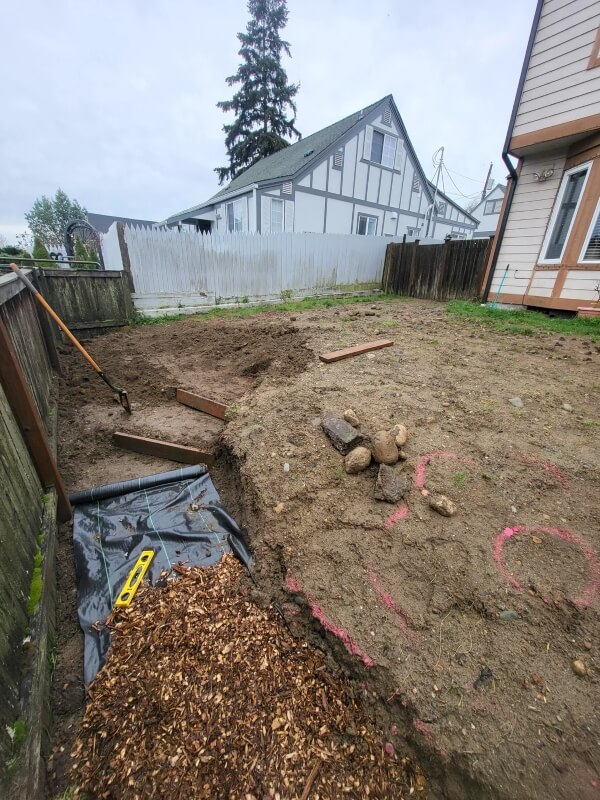A barren backyard with construction equipment.