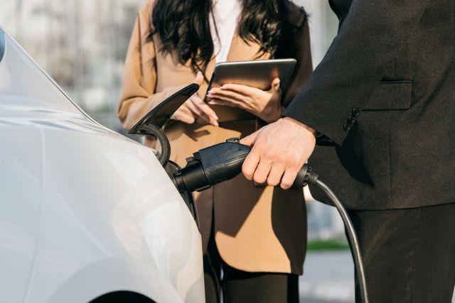 A businessman charging his electric car.