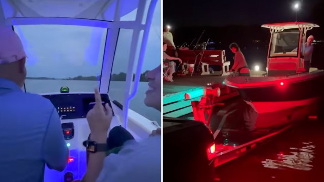 A person steering a boat while another takes a selfie, with a cloudy sky and water in the background.