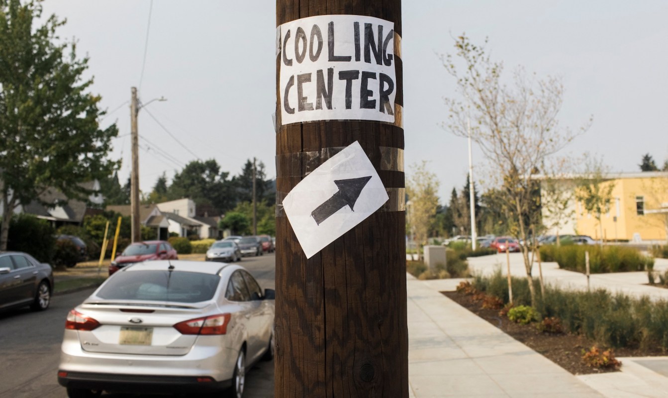 A sign on a utility pole directing people to a cooling center.