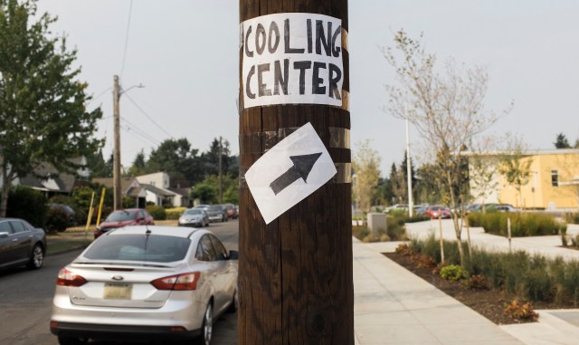 A sign on a utility pole directing people to a cooling center.