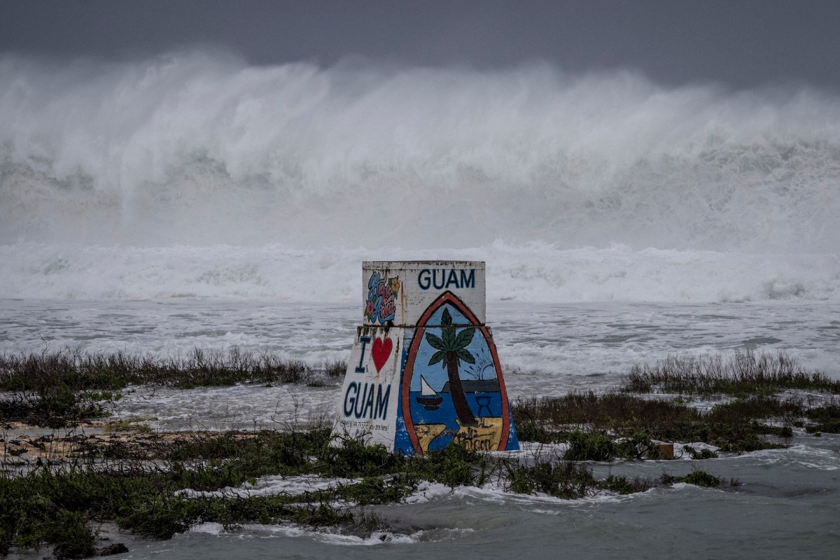An "I Love Guam" sign in front of stormy waters.