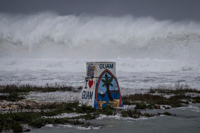An "I Love Guam" sign in front of stormy waters.