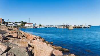 A rocky shoreline overlooking a calm harbor.