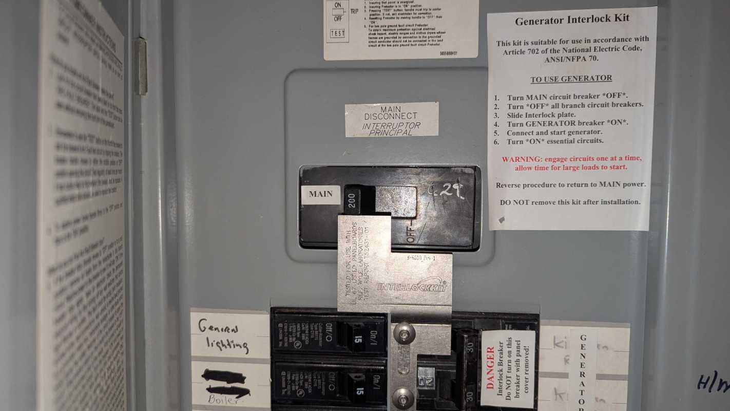 A close-up view of a residential circuit breaker panel with labels and instructions for generator interlock use.