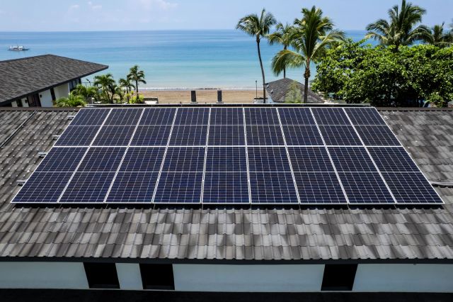 Rooftop solar panels on a beachfront building.