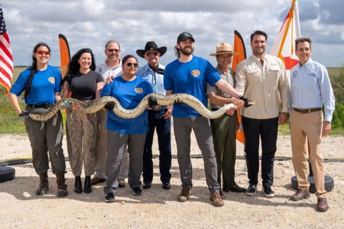 A group holding a python.