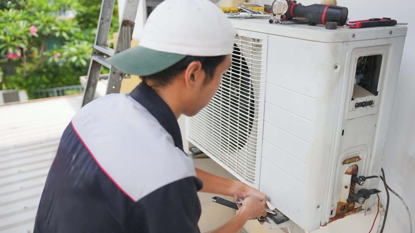 A technician repairs an air conditioning unit.
