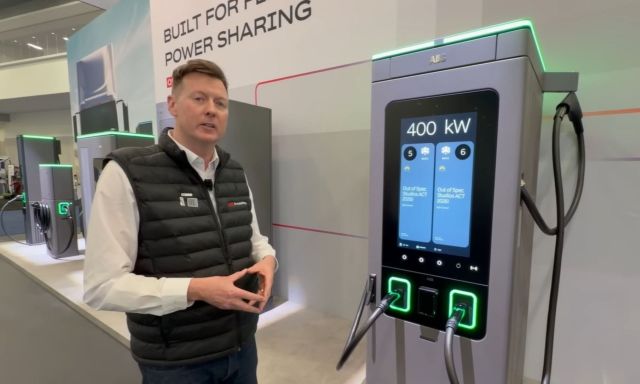 A person standing next to an ABB EV charger.