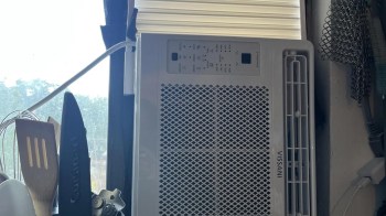 A window AC unit installed sideways in a kitchen.