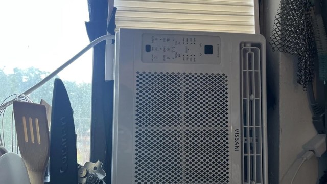 A window AC unit installed sideways in a kitchen.