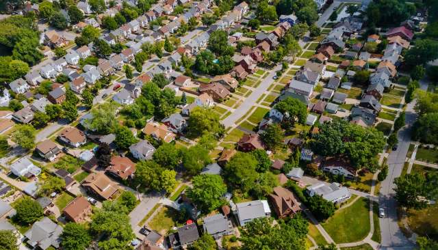 An aerial view of a residential neighborhood featuring houses, trees, and well-defined streets.