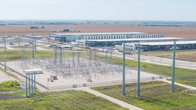 An industrial area featuring a power substation and large modern buildings in an open landscape.